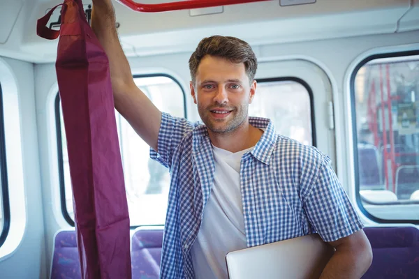 Man holding laptop while travelling in train — Stock fotografie