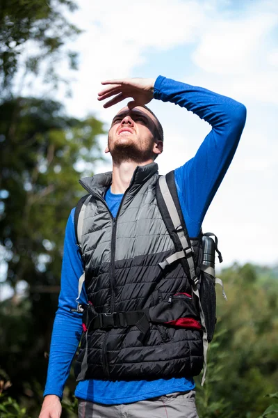 Manliga hiker skärmning hans ögon — Stockfoto