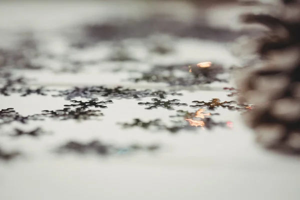 圣诞节期间木桌上的松锥和雪花 — 图库照片