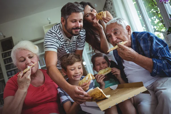 Multi-generation family having pizza together — Stockfoto
