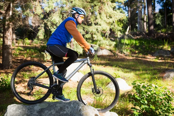 Mężczyzna mountain biker jazdy na rowerze w lesie — Zdjęcie stockowe