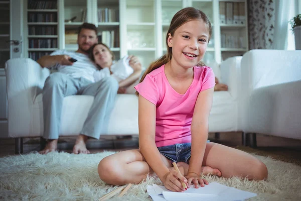 Girl sitting on the floor and drawing — Stockfoto
