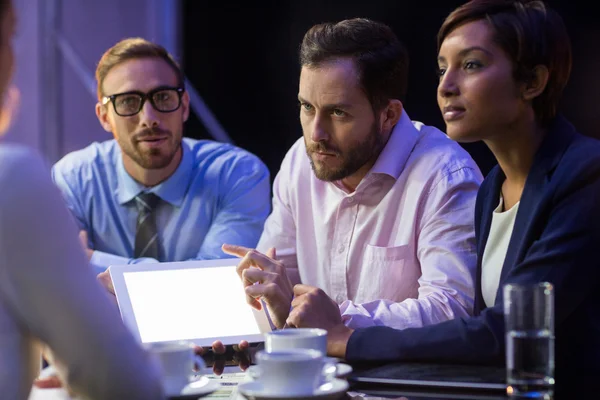 Empresario discutiendo en tableta con colegas — Foto de Stock