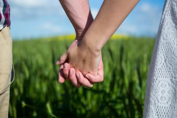 Couple tenant la main dans le champ — Photo