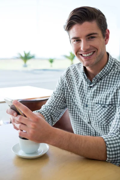 Людина використовує свій телефон в кав'ярні — стокове фото