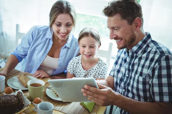 Famille utilisant une tablette numérique tout en prenant le petit déjeuner — Photo