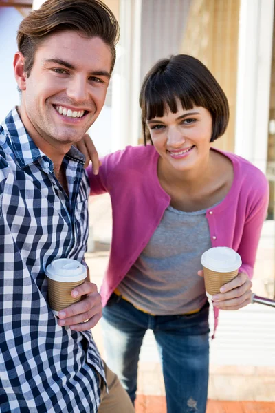 Casal com xícaras de café olhando para a câmera — Fotografia de Stock