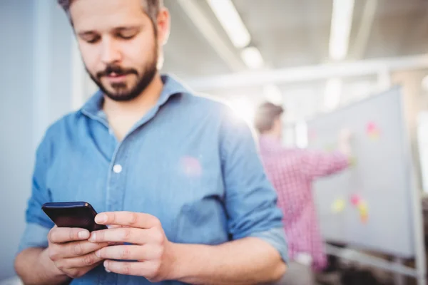 Biznesmen wiadomości tekstowe na telefon komórkowy w biurze creative — Zdjęcie stockowe