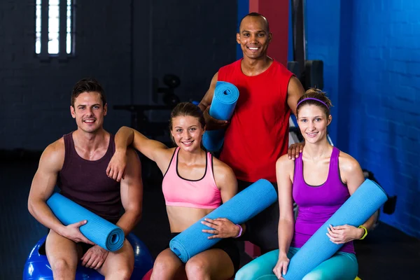 Lächelnde Freunde mit Gymnastikmatten — Stockfoto