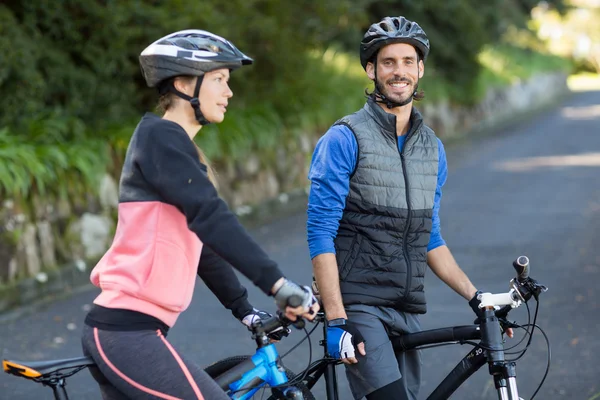 Байкерская пара с горным велосипедом на дороге — стоковое фото
