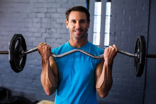Smiling man exercising with barbell — Stock Photo, Image