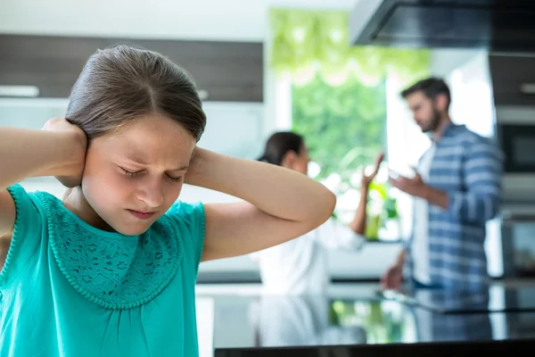 Girl covering her ears while parents arguing — Stockfoto