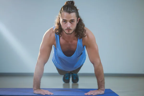 Hombre haciendo push-up en la alfombra de ejercicio —  Fotos de Stock