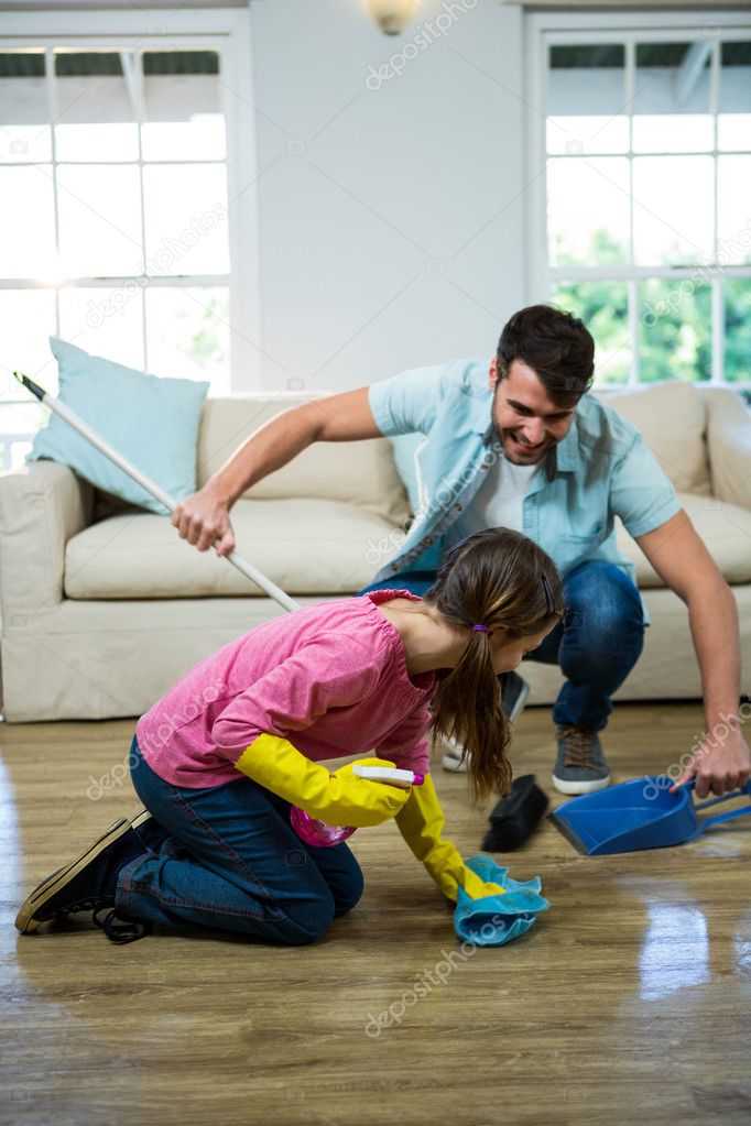 Joven con su hija haciendo ejercicios de yoga en el suelo en el salón