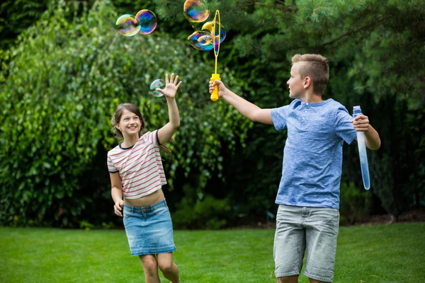 Kids playing with bubbles in the park — Stock Photo, Image