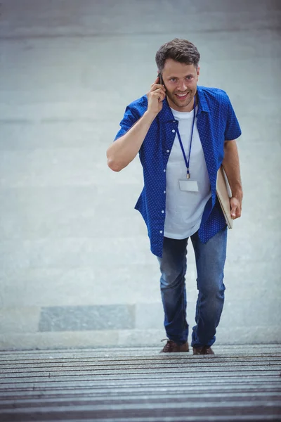Telefonla konuşurken merdivenlerde yürüyen adam — Stok fotoğraf