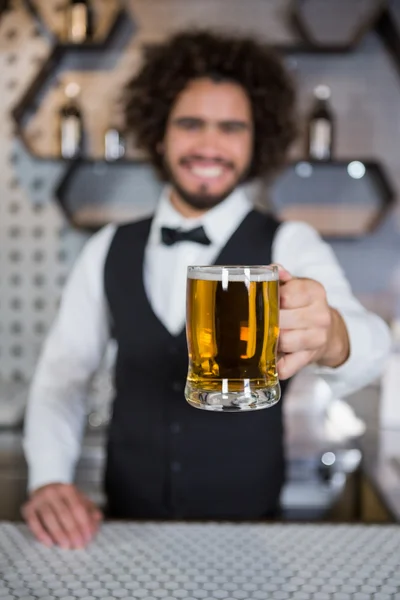 Barman segurando vidro de cerveja no balcão do bar — Fotografia de Stock