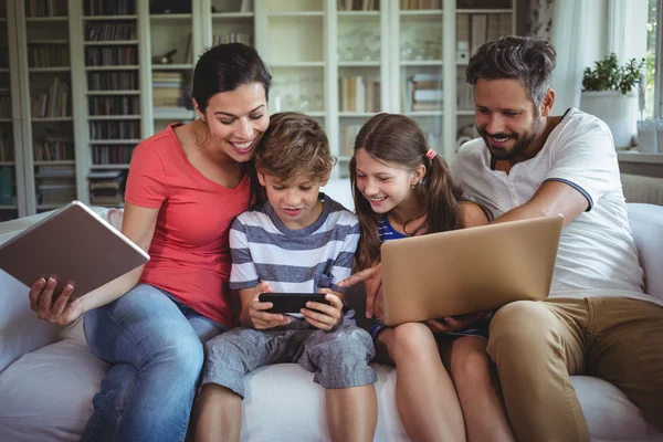 Familj med bärbar dator, telefon och surfplatta — Stockfoto