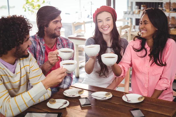 Счастливые друзья, держащие чашки кофе — стоковое фото