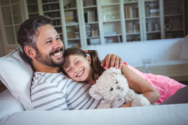 Father lying on sofa with daughter — Stock Photo, Image