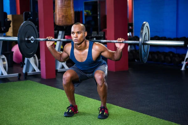 Young man weightlifting in fitness studio — Stock Photo, Image