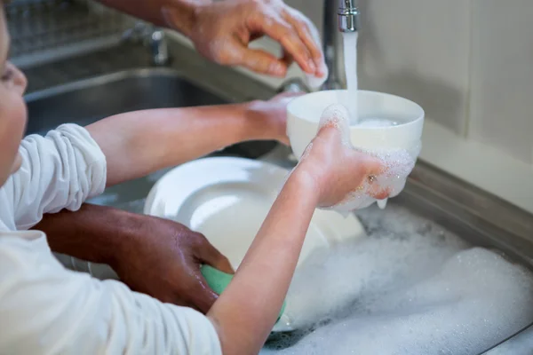 Son helping father in washing utensils — Stock Photo, Image