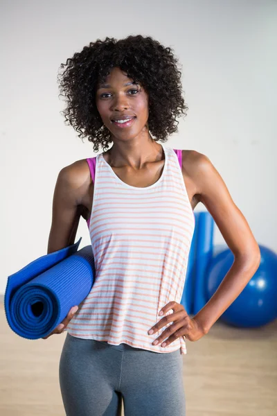 Женщина держит мат для упражнений — стоковое фото
