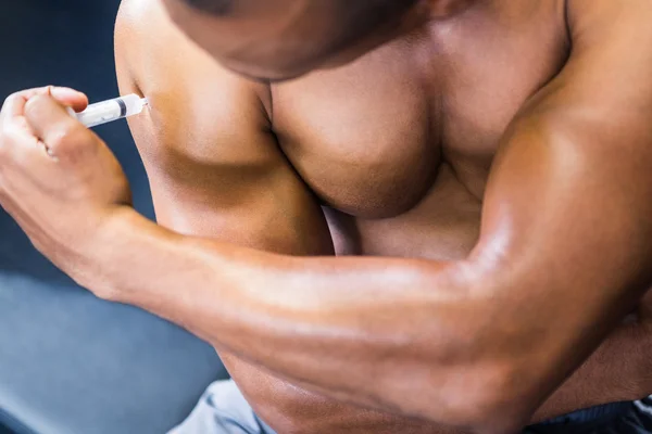 Мускулистый человек вводит стероиды — стоковое фото
