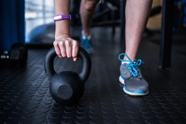 Atletka drží kettlebell v tělocvičně — Stock fotografie