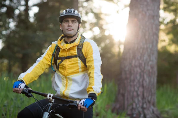 Motociclista masculino com bicicleta de montanha na floresta — Fotografia de Stock