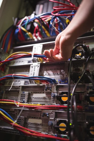 Técnico enchufando el cable de conexión en el servidor montado en rack — Foto de Stock