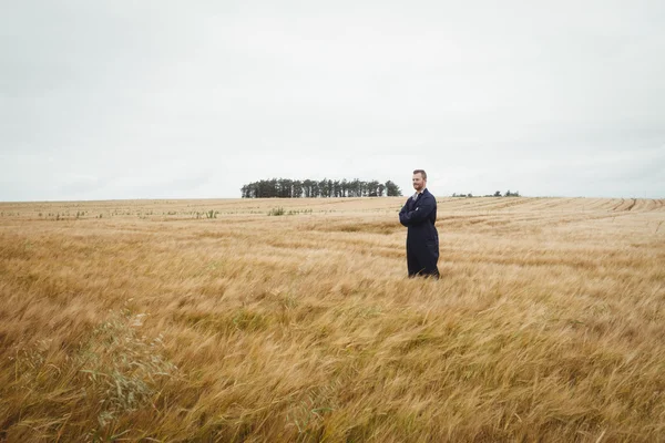 Farmář stál s rukama přešel v poli — Stock fotografie