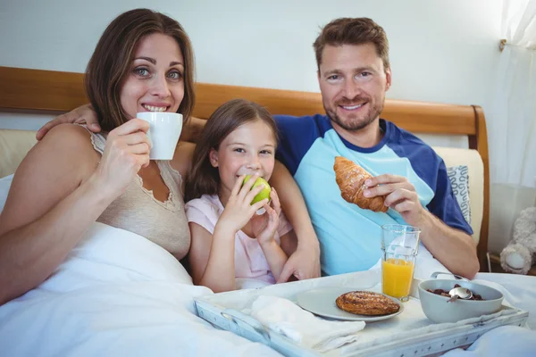 Parents with daughter and having breakfast — Stock Photo, Image