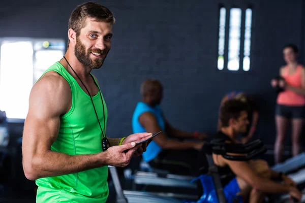 Lachende hipster holding tablet in sportschool — Stockfoto