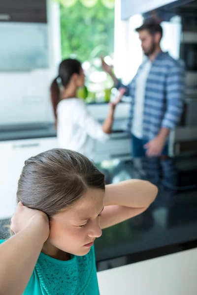 Девочка закрывает уши, пока родители спорят — стоковое фото