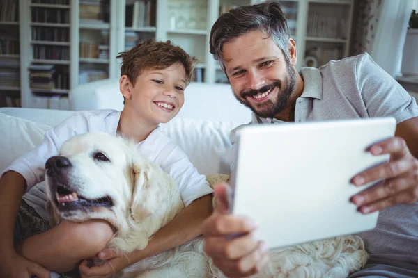 Padre e hijo con perro mascota usando tableta —  Fotos de Stock