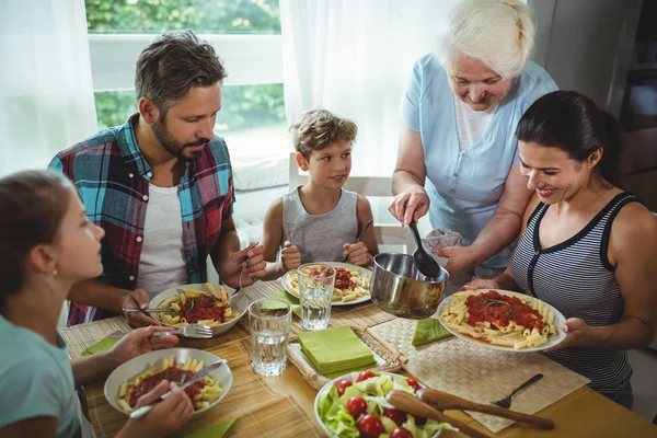 Idosa servindo refeição para sua família — Fotografia de Stock
