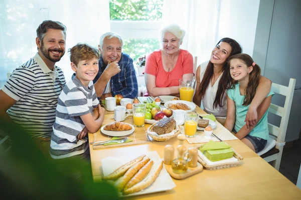 Багатоповерхова сім'я сидить за столом сніданку — стокове фото