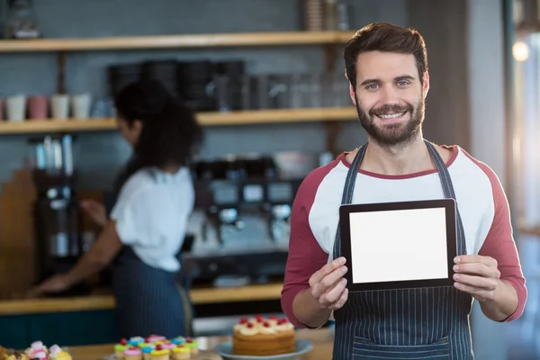 Pelayan yang menunjukkan tablet digital di counter — Stok Foto