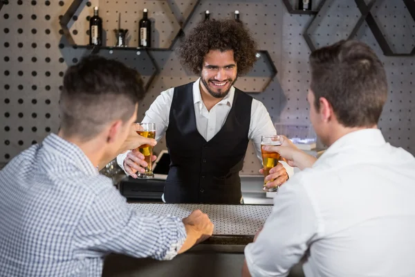 Bartender serving beer to customers — Stock Photo, Image