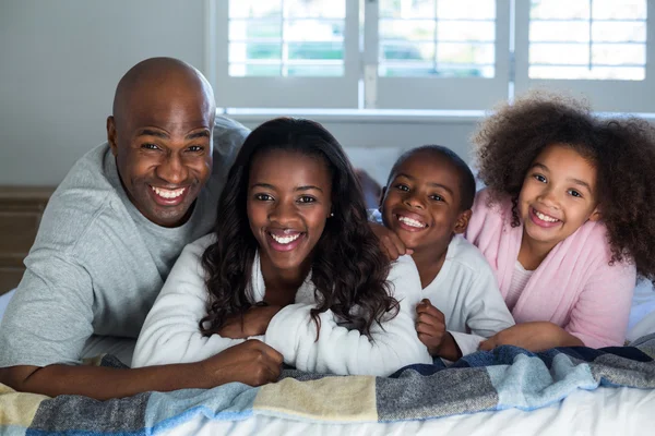 Liggend op bed en gelukkige familie — Stockfoto