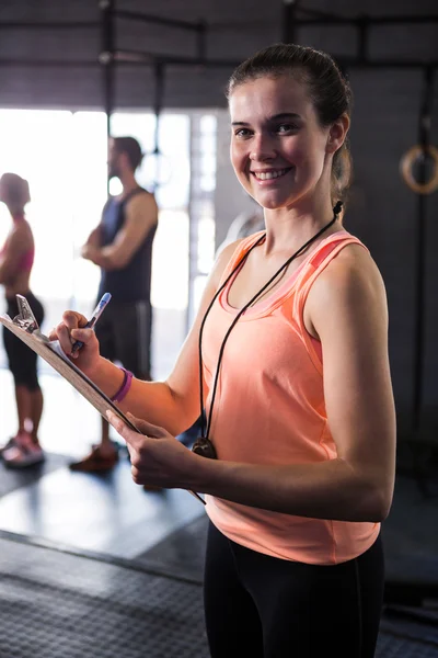 Instrutor de fitness feminino alegre segurando prancheta — Fotografia de Stock