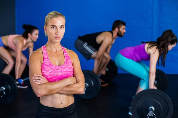 Kobieta stoi przy jednoczesnym ludzi uprawiających sport — Zdjęcie stockowe