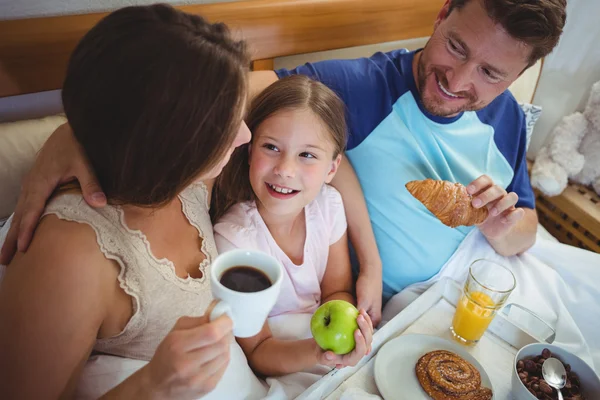 Parents with daughter and having breakfast — Stockfoto