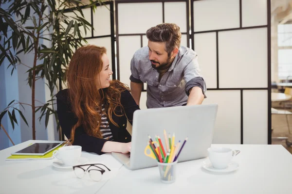 Colegas dicussing ao usar laptop — Fotografia de Stock