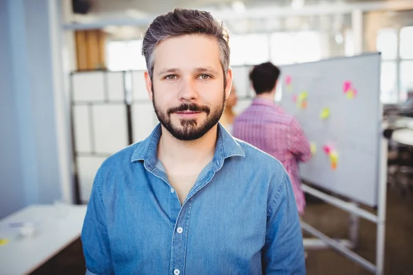 Handsome businessman standing at creative office — Stock Photo, Image