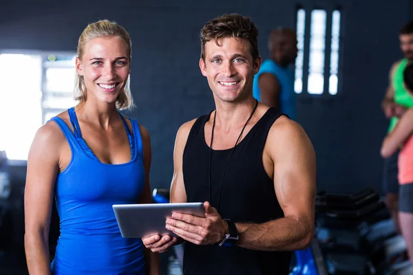 Lächelnde Freunde mit digitalem Tablet im Fitnessstudio — Stockfoto