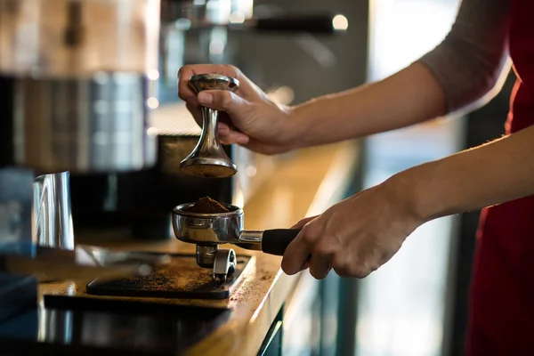 Kellner mit Stampfer, um gemahlenen Kaffee zu pressen — Stockfoto