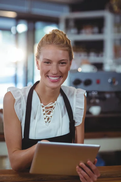 Waitress standing at counter using tablet — Stock Photo, Image