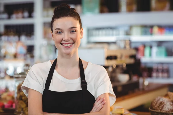Усміхнена офіціантка стоїть з схрещеними руками — стокове фото